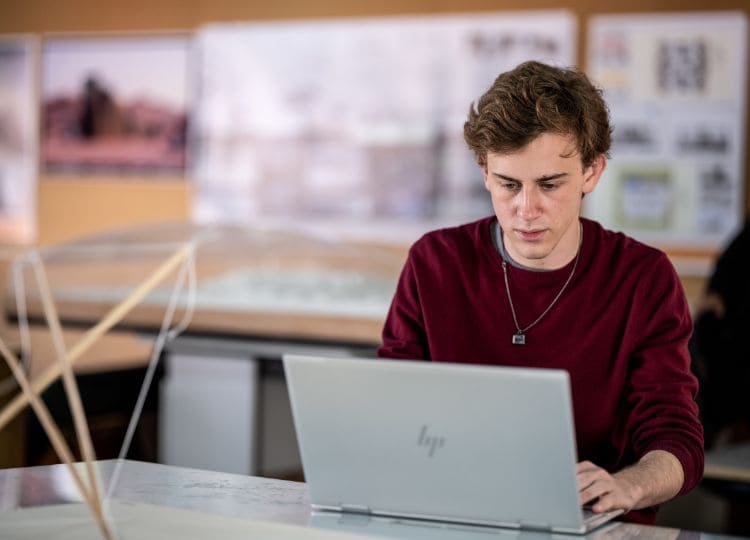 alumno estudiando computadora