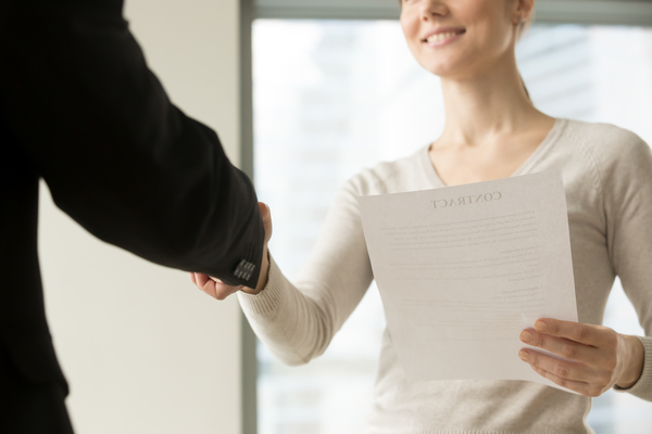 mujer estrechando la mano sosteniendo su cv