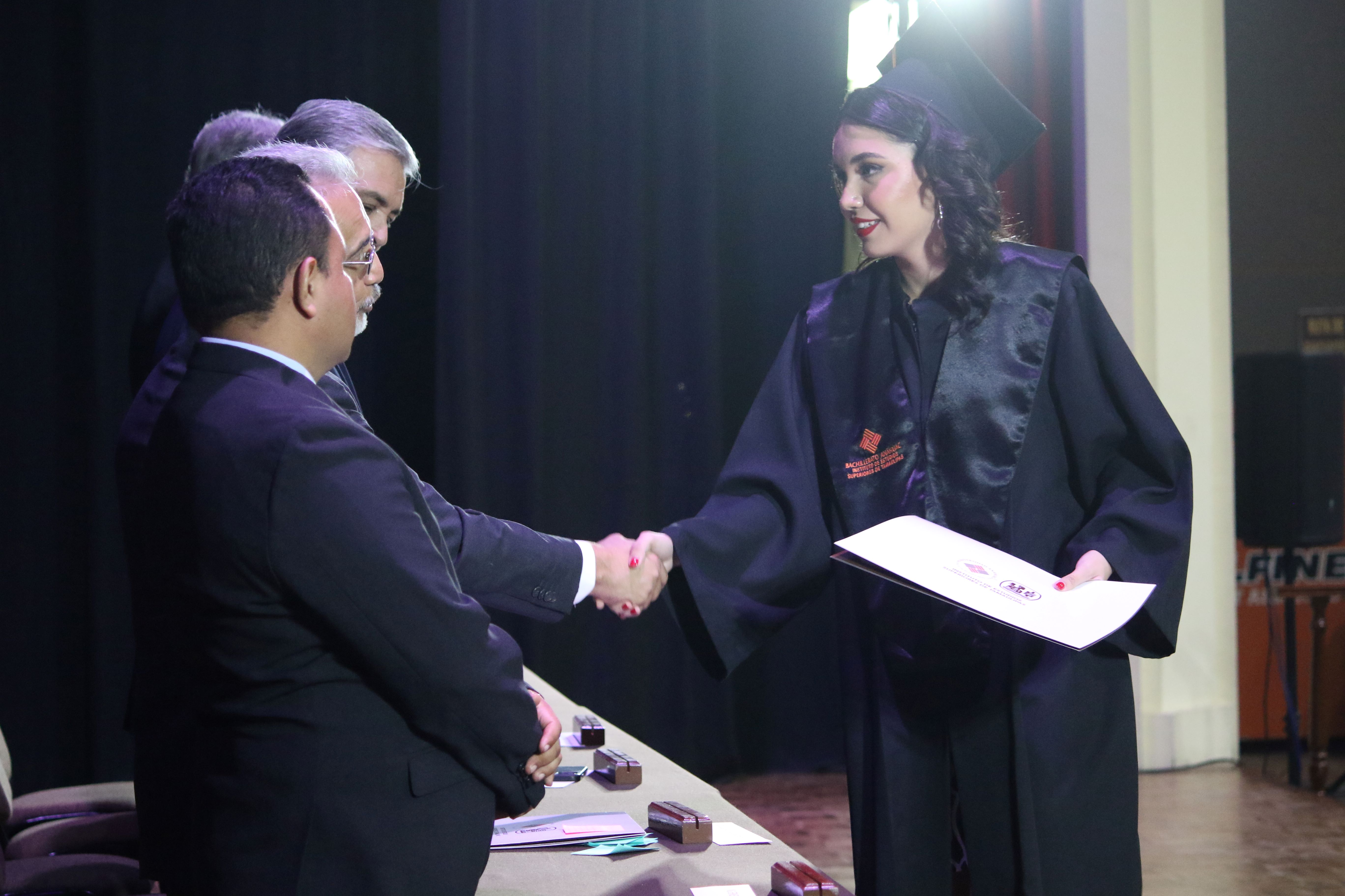 Alumna recibe su diploma en el presidium.
