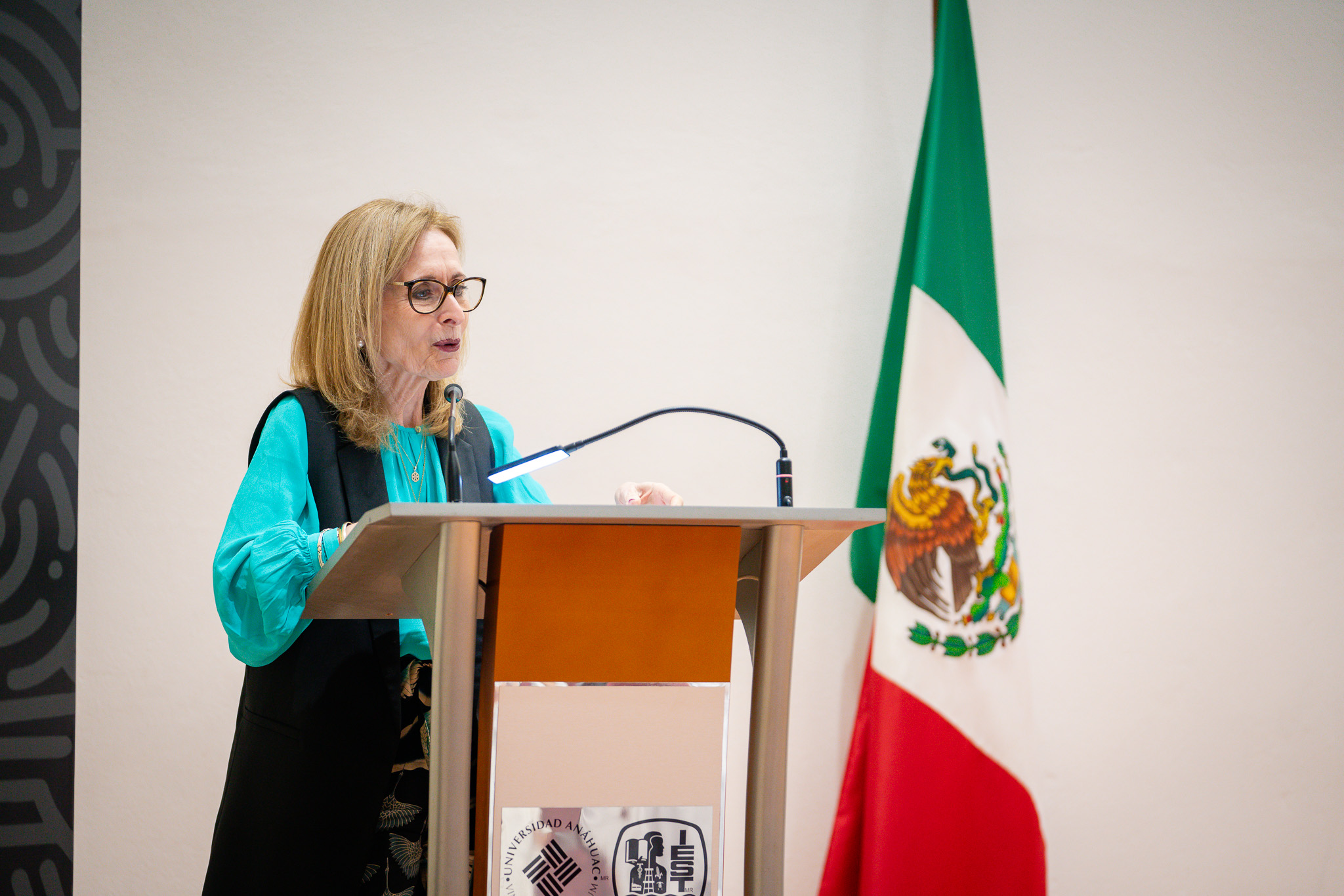 Rectora en el podio, en la ceremonia de reconocimientos de excelencia de preparatoria.