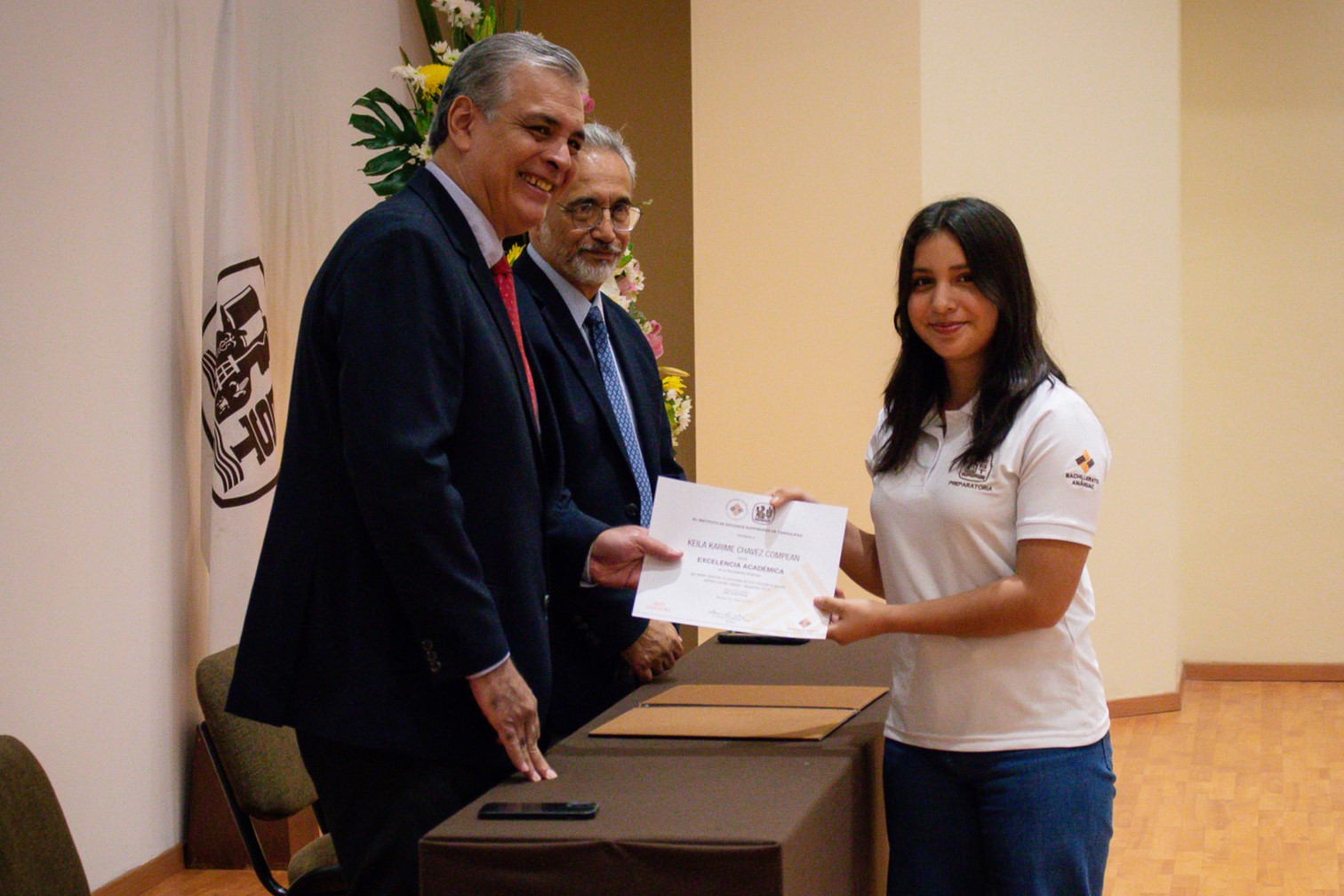 Lalo y Luis Alfonso entregando reconocimiento a una alumna de prepa.